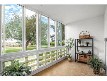 Bright sunroom with ample natural light and view of the backyard at 9155 E Center Ave # 10A, Denver, CO 80247