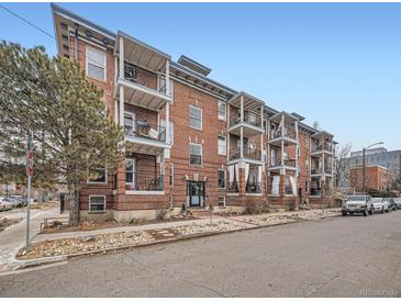 Brick apartment building featuring multiple balconies and a well-maintained landscaped entrance at 1374 N Ogden St # C, Denver, CO 80218