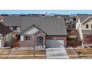 Charming single-Gathering home featuring a well-maintained lawn, brick facade, and attached two-car garage at 5280 Longs Peak St, Brighton, CO 80601
