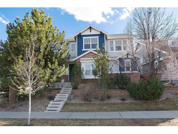Charming two-story home featuring a well-maintained front yard and inviting entrance with decorative trees and brickwork at 9690 E 5Th Ave, Denver, CO 80230