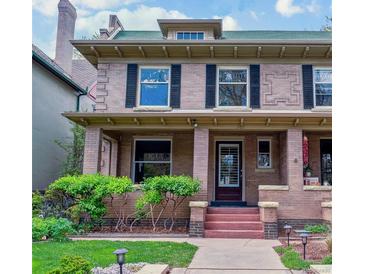 Charming two-story brick home featuring a cozy front porch and well-manicured lawn at 761 N Lafayette St, Denver, CO 80218