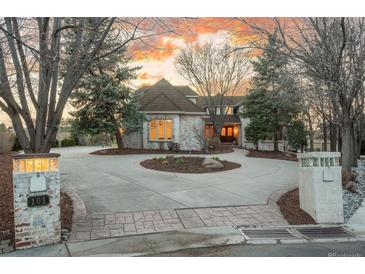 Elegant home with a circular driveway, manicured landscaping, and brick accents creating a welcoming curb appeal at 101 Glenmoor Ln, Cherry Hills Village, CO 80113