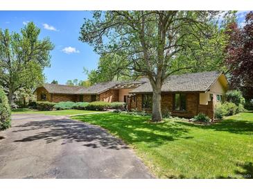 Beautiful brick home with a well-manicured lawn and mature trees creating a park-like setting at 5196 S Williams Dr, Greenwood Village, CO 80121