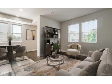 Bright living room featuring contemporary furnishings, modern shelving, and ample natural light from large windows at 16069 E Elk Dr, Denver, CO 80239