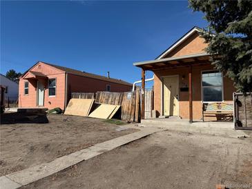 Exterior view of two homes with dirt yards, needing landscaping and improvements at 723 Newton St, Denver, CO 80204