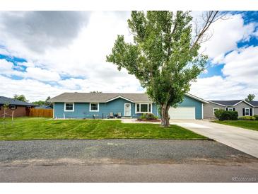 Charming blue ranch home featuring a well-manicured lawn and inviting curb appeal at 1853 Burton St, Strasburg, CO 80136