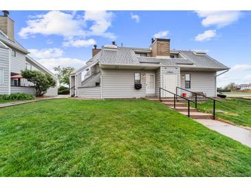 Charming townhome with manicured lawn, gray siding, and inviting entrance steps at 17004 E Tennessee Dr # 103, Aurora, CO 80017