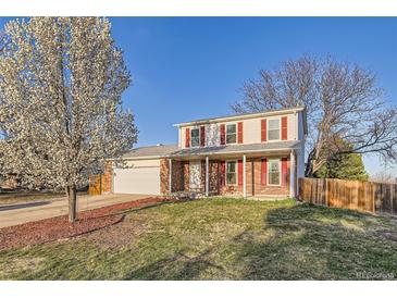 Charming two-story home featuring red shutters, brick accents, a well-maintained lawn, and mature trees at 5155 E 108Th Pl, Thornton, CO 80233