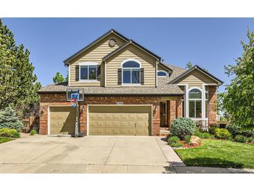 Charming two-story home featuring a brick and siding exterior with a well-maintained front yard at 6366 Umber Cir, Arvada, CO 80403