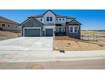 Charming two-story home with stone and white siding, three-car garage, and well-maintained landscaping at 4949 Hickory Oaks St, Castle Rock, CO 80104