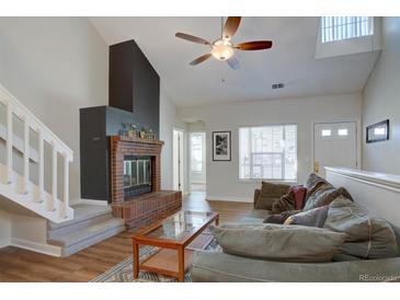 Spacious living area featuring a fireplace, staircase, and cozy seating arrangement at 3030 W Prentice Ave # G, Littleton, CO 80123