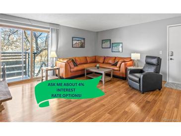 Bright living room with hardwood floors, large sectional sofa, and sliding glass door to balcony at 6505 Kalua Rd # 204B, Boulder, CO 80301