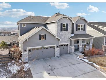 Beautiful two-story home with grey siding, stone accents, and a three-car garage at 20223 Terrace View Dr, Parker, CO 80134