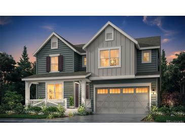 Charming two-story home featuring board and batten and horizontal siding, a porch, and a two-car garage at 199 Wooten Ave, Brighton, CO 80601