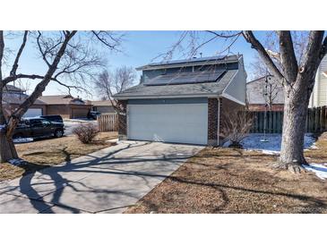 Two-story home with a two-car garage, solar panels and a concrete driveway at 7103 Depew Ct, Arvada, CO 80003