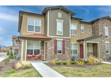 Charming townhome exterior features stone accents, a cozy front patio, and well-maintained landscaping at 8376 Lorenzo Ln # A, Highlands Ranch, CO 80129
