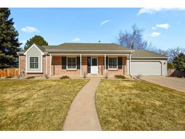 Charming brick home with a well-manicured front yard and inviting walkway at 9161 W Hialeah Pl, Littleton, CO 80123