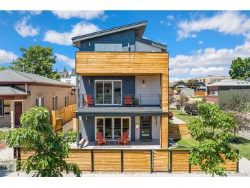 Modern three-story home featuring wood accents and a welcoming front porch at 3657 Pecos St, Denver, CO 80211