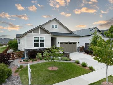 Charming home with a well-manicured lawn, beautiful landscaping, and a welcoming two-car garage at 565 Pikes View Dr, Erie, CO 80516