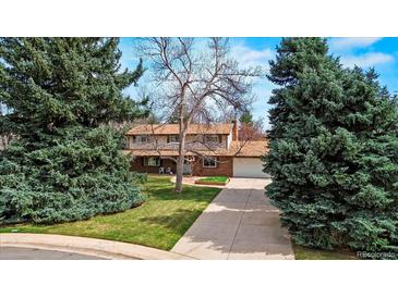 Charming home with a spacious front yard, mature trees, and long driveway at 6196 S Rosewood Dr, Littleton, CO 80121
