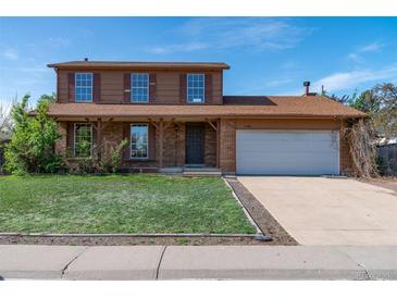 Two story home featuring a well-manicured lawn, brick accents, and an attached two-car garage at 11098 Fairfax Way, Thornton, CO 80233