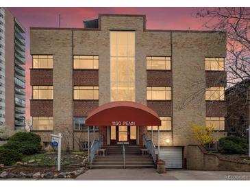 Brick apartment building at 1130 Penn with covered entry and colorful sunset at 1130 N N Pennsylvania St # 306, Denver, CO 80203