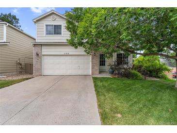 Charming two-story home featuring a brick-accented facade, mature tree, and a well-maintained front lawn at 11313 Haswell Dr, Parker, CO 80134
