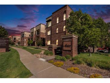 Brick apartment building with manicured landscaping and clear community signage, setting a welcoming tone at 301 Inverness S Way # 202, Englewood, CO 80112