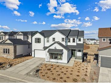 A charming two-story home features white siding, black accents, a two-car garage, and a beautifully landscaped front yard at 3976 Breakcamp Ct, Castle Rock, CO 80108