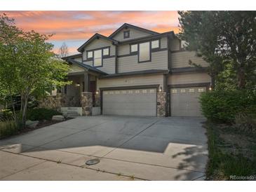 Beautiful two-story home with a two-car garage, stone accents, manicured lawn, and vibrant sunset backdrop at 13075 Tamarac St, Thornton, CO 80602