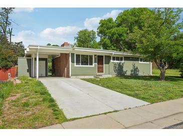 Charming home with a well-maintained lawn, a brick chimney, and a long driveway at 6155 Carr St, Arvada, CO 80004