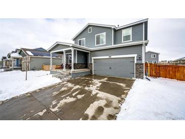 Two-story house with gray siding, attached garage, and covered porch at 47387 Lilac Ave, Bennett, CO 80102