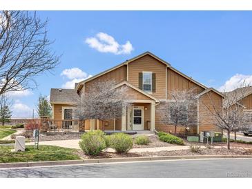 Charming tan two-story home featuring a cozy front porch and well-maintained landscaping on a sunny day at 4822 Pathfinder Ct, Castle Rock, CO 80108