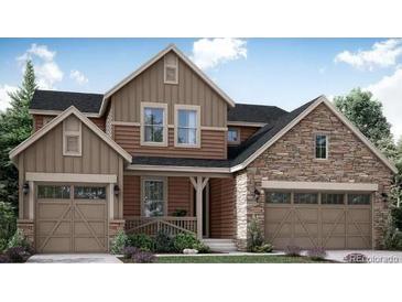 Beautiful two-story home featuring a stone and siding exterior, attached garages, and manicured landscaping at 14533 Hudson Way, Thornton, CO 80602