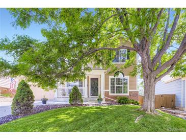 Charming two-story home with a well-manicured lawn and mature tree providing shade, enhancing curb appeal at 9264 Fox Fire Ln, Highlands Ranch, CO 80129