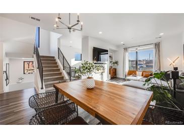Bright living room with a staircase, a flat screen TV, and large windows offering natural light at 3011 W 53Rd Ave, Denver, CO 80221