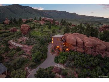 Stunning modern home seamlessly integrated with natural rock formations in a picturesque landscape at 6619 Apache Pl, Larkspur, CO 80118