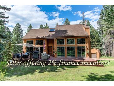 Beautiful two-story home with large windows, a spacious deck, and mature trees offering privacy at 25257 Snyder Ave, Conifer, CO 80433