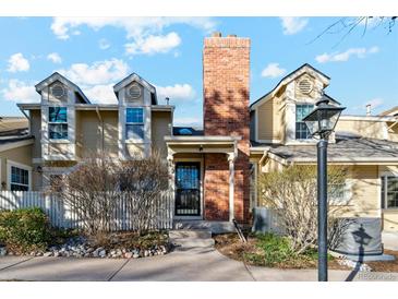 Charming exterior of a townhouse with a brick chimney, dormer windows and a front porch at 2891 W Long Dr # D, Littleton, CO 80120