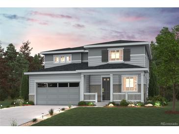 Charming two-story home with a covered porch, attached garage, and beautifully landscaped front yard at 3464 N Irvington St, Aurora, CO 80019