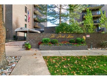 Community entrance with manicured landscaping, brick facade, and covered entry at The Park Lane Condominiums at 460 S Marion Pkwy # 453, Denver, CO 80209