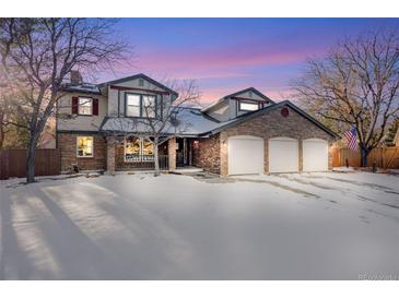 Two-story brick home with three-car garage and snowy front yard at 16504 E Dorado Ave, Centennial, CO 80015