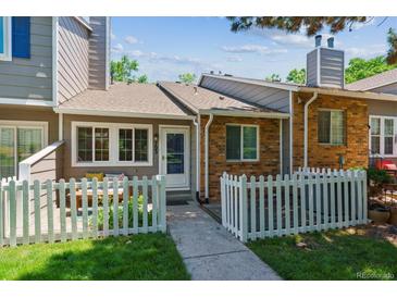 Charming townhome with a fenced front yard, patio and well-maintained lawn at 703 S Depew St, Lakewood, CO 80226