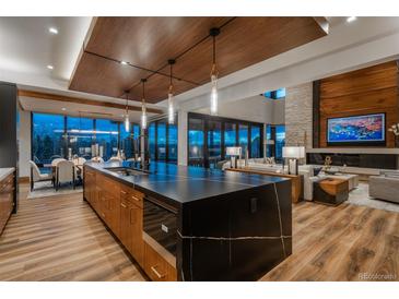 Gourmet kitchen featuring a large island, breakfast bar, and an open concept design at 5140 S Kearney Ct, Greenwood Village, CO 80111