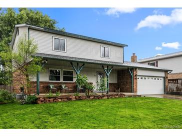 Charming two-story home with a welcoming front porch, fresh lawn, and attached two car garage at 4550 E 121St Pl, Thornton, CO 80241