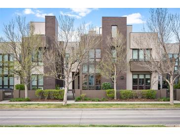 Modern townhome with a well-manicured lawn and contemporary architectural details at 8071 E 29Th Ave, Denver, CO 80238