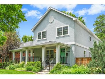 Inviting two-story home featuring a charming front porch with a vibrant turquoise-colored front door at 2485 S Fillmore St, Denver, CO 80210