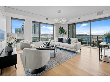 Bright living room featuring hardwood floors, stylish furnishings, large windows with city views and modern lighting at 1750 Wewatta St # 1501, Denver, CO 80202