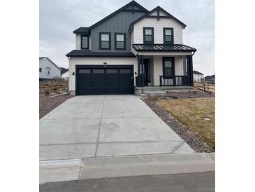 Charming two-story home featuring a covered porch, a two-car garage and modern black and white color scheme at 1041 W Witherspoon Dr, Elizabeth, CO 80107