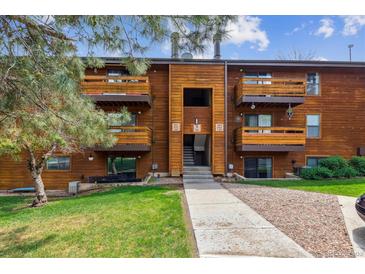 Charming brown wood condo with multiple balconies and well-maintained lawn and landscape at 331 Wright St # 108, Lakewood, CO 80228